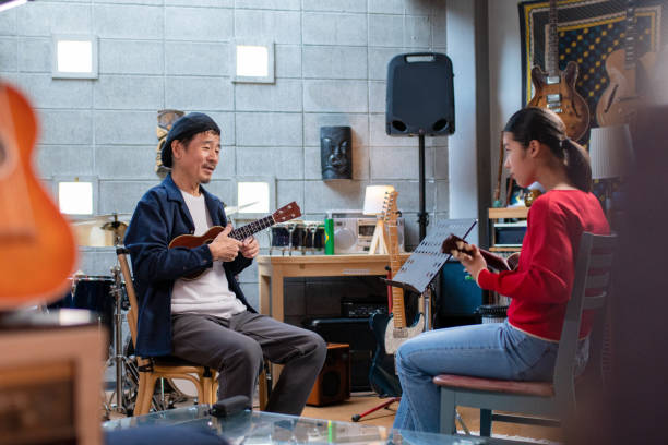 istock Pre-adolescent girl having ukulele lessons 1364371957