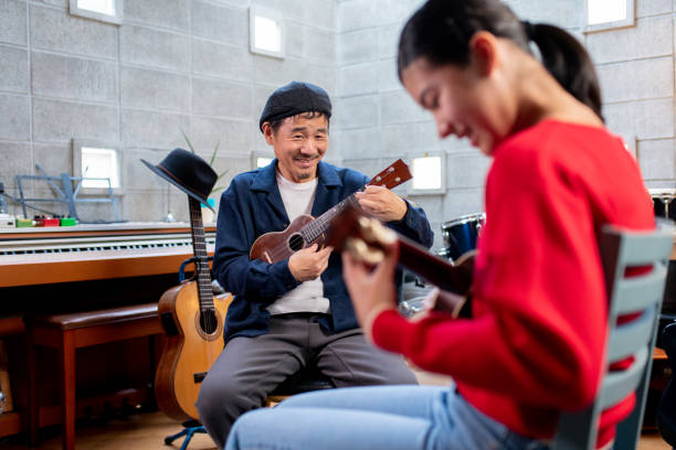 istock Pre-adolescent girl having ukulele lessons 1364371960