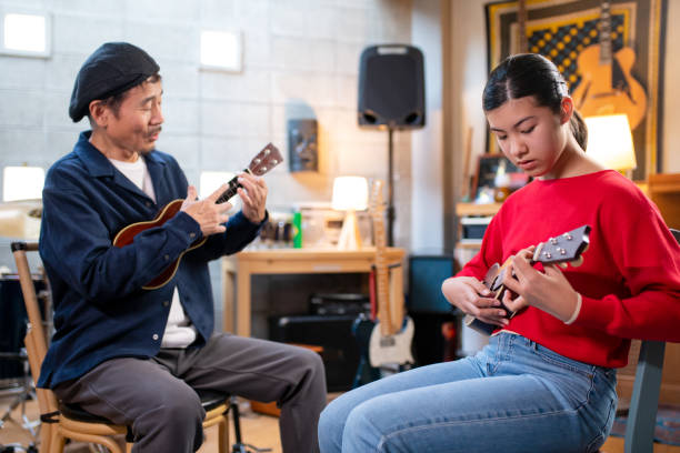 istock Pre-adolescent student learning how to play the ukulele 1364371962