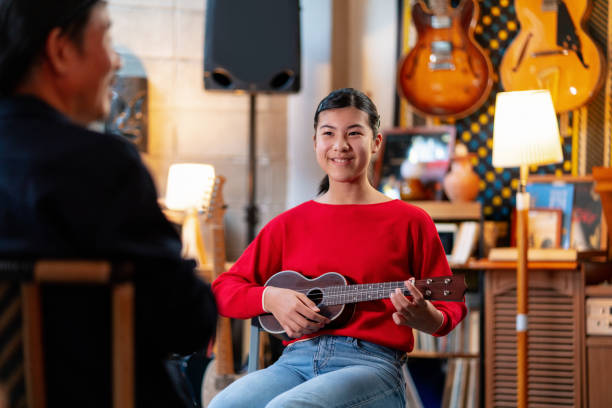 istock Pre-adolescent girl learning how to play the ukulele 1364371994