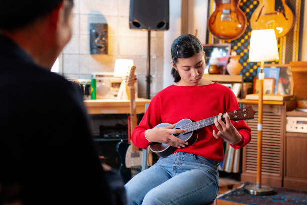 istock Pre-adolescent girl learning how to play the ukulele 1364371996