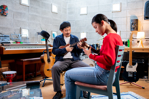 Pre-adolescent girl having ukulele lessons. Okayama, Japan
