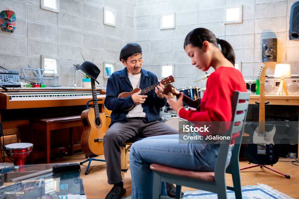 Pre-adolescent girl having ukulele lessons Pre-adolescent girl having ukulele lessons. Okayama, Japan Music Stock Photo
