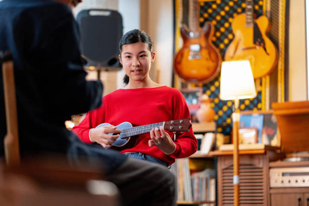 istock Pre-adolescent girl learning how to play the ukulele 1364372171