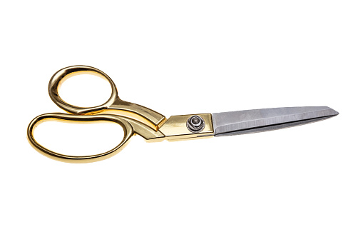 Scissors with golden handle isolated cutout on white background. Tailor, barber professional equipment