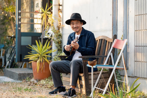 istock Mature man playing ukulele outdoors 1364372287