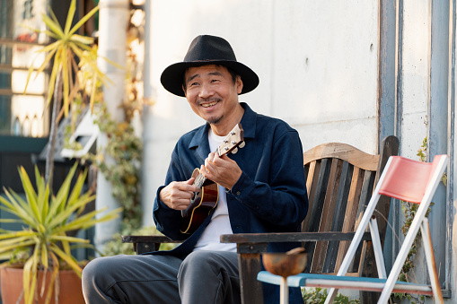 Portrait of a happy looking mature man with an ukulele. Okayama, Japan