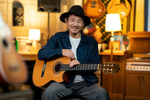 Portrait of a stylish mature Japanese man with a guitar. Okayama, Japan