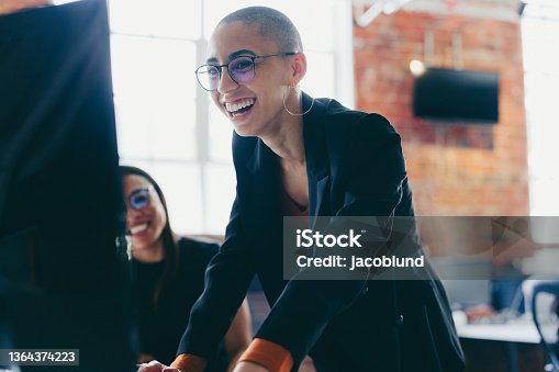 istock Young businesswoman using a desktop while working with her colle 1364374223