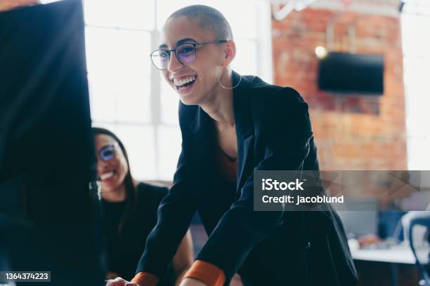 Young Businesswoman Using A Desktop While Working With Her Colle Stock Photo - Download Image Now