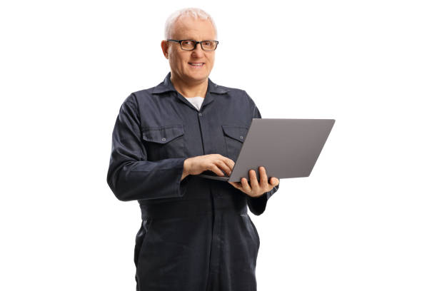 istock Mature male worker in an overall uniform with a laptop computer 1364374352