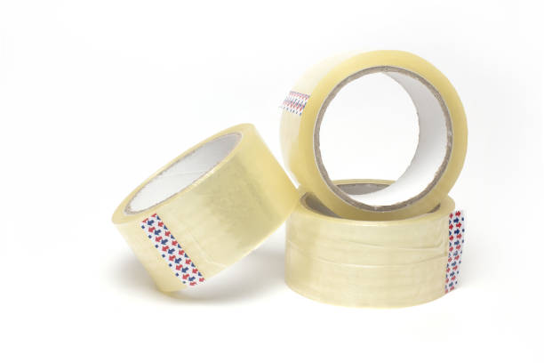 rollos de paquete transparente cinta adhesiva de fondo apilado - packaging tape fotografías e imágenes de stock