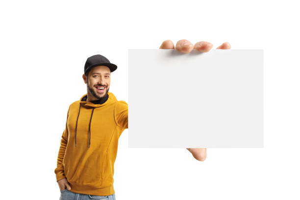 istock Cheerful young man with a yellow sweatshirt holding a blank card 1364374893