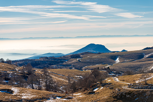 Winter landscape of the Lessinia plateau (Altopiano della Lessinia) and the  Padana Plain or Po valley with fog. On horizont the mountain range of the Apennines. Erbezzo, Verona, Veneto, Italy, Europe