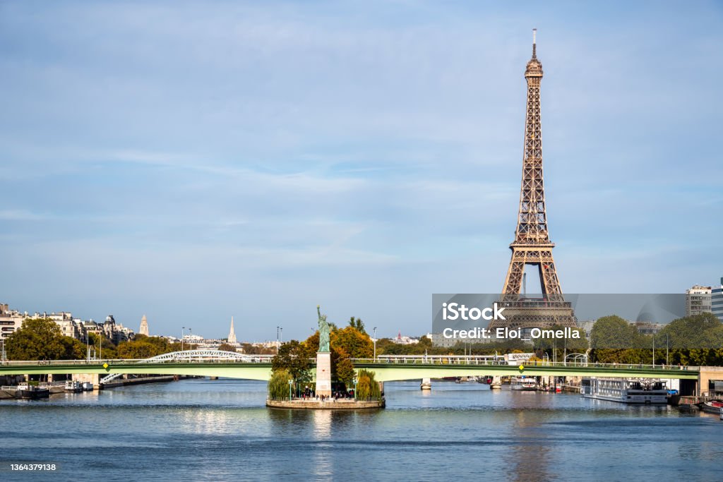 Statue of Liberty at the Seine in Paris The Paris version of the Statue of Liberty, on a small island in the Seine river. Eiffel tower in the background Paris - France Stock Photo