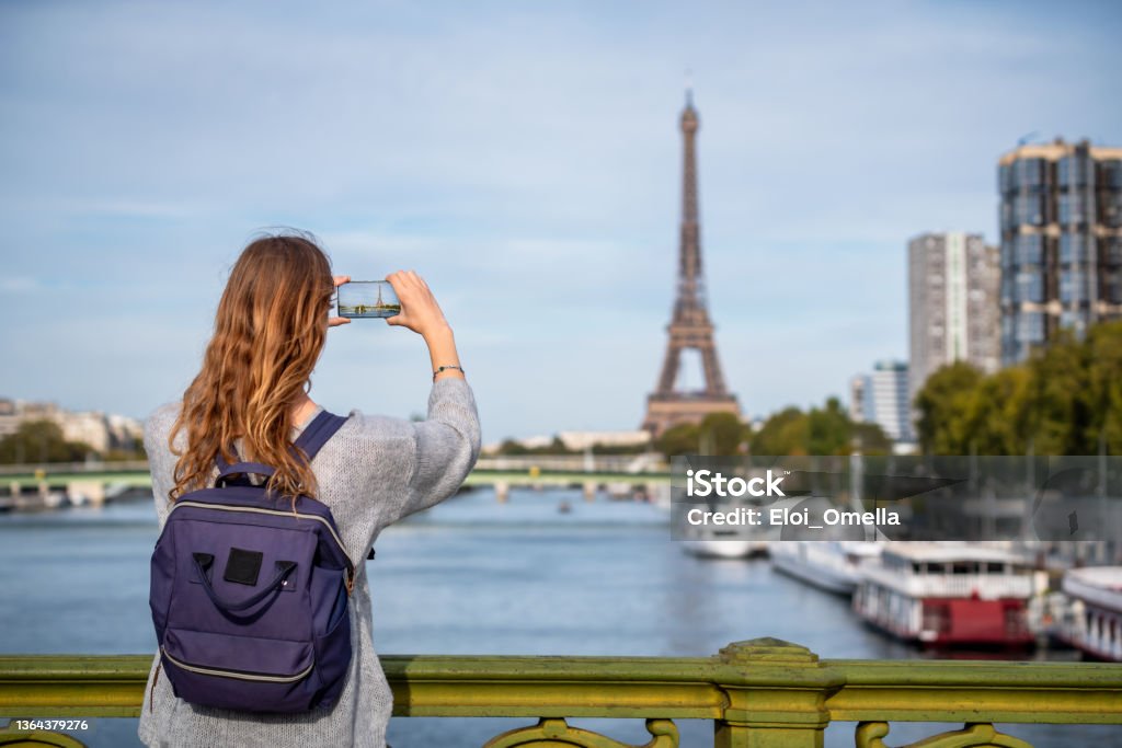 Tourist taking photo of Eiffel tower in Paris tourist taking photo of Eiffel tower in Paris with a smartphone, travel in Europe Paris - France Stock Photo