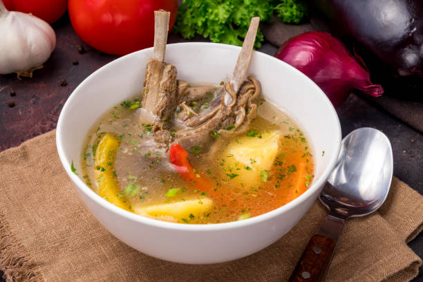 shurpa asian soup with lamb, potatoes and carrot on white bowl on dark table stock photo