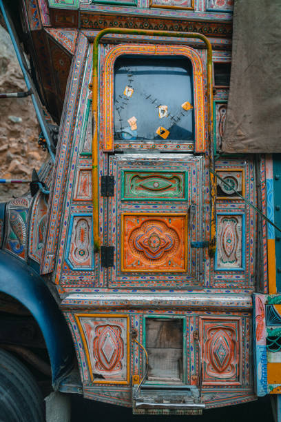 A vibrant scene showcasing colorful jeepneys lined up in a bustling bus station. The background features artistic murals, adding cultural and aesthetic appeal to the urban environment.