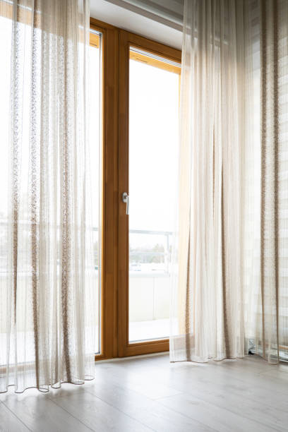 istock Large windows with transparent curtains in living room. 1364382563