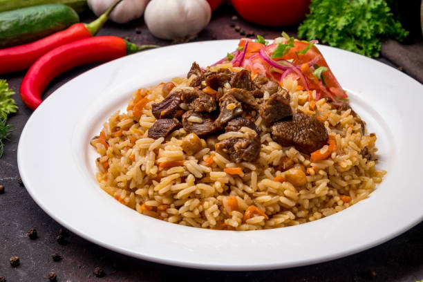 istock pilaf with beef and vegettables salad on white plate on dark table 1364382888