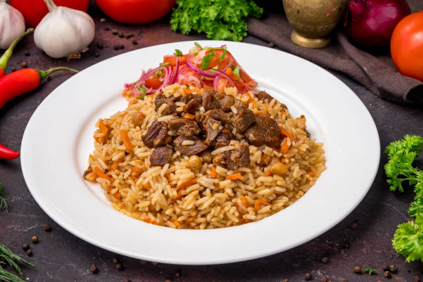 istock pilaf with beef and vegettables salad on white plate on dark table 1364383500