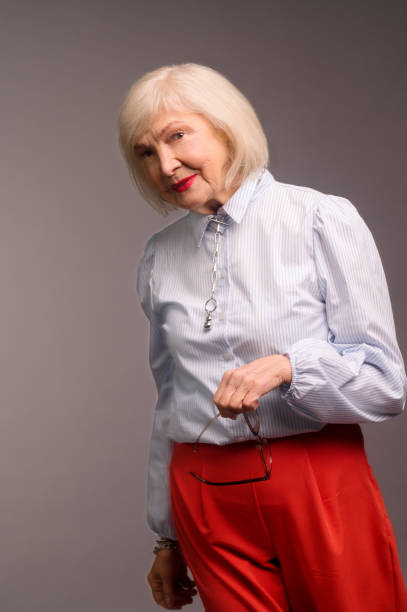 istock Stylish senior woman in white blouse looking confident 1364384123