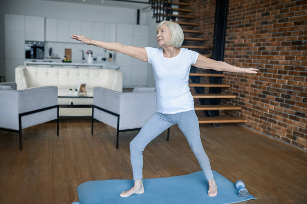 istock A senior woman standing in a warrior pose 1364384187