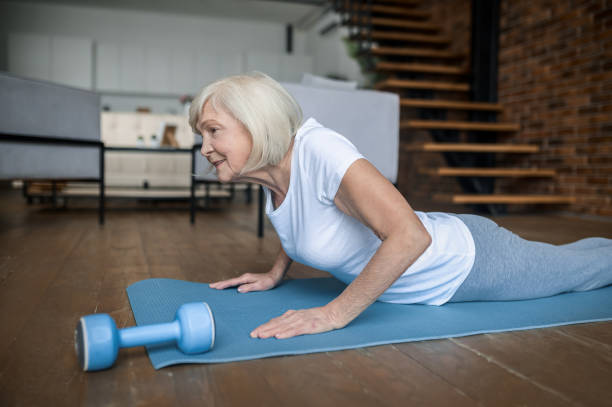 istock Senior active woman in a white tshirt doing plank 1364384205