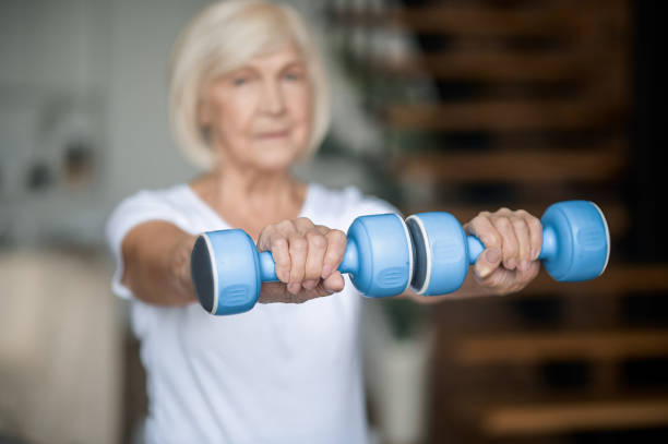 istock Active senior woman with dumbbells in hands doing her workout 1364384225