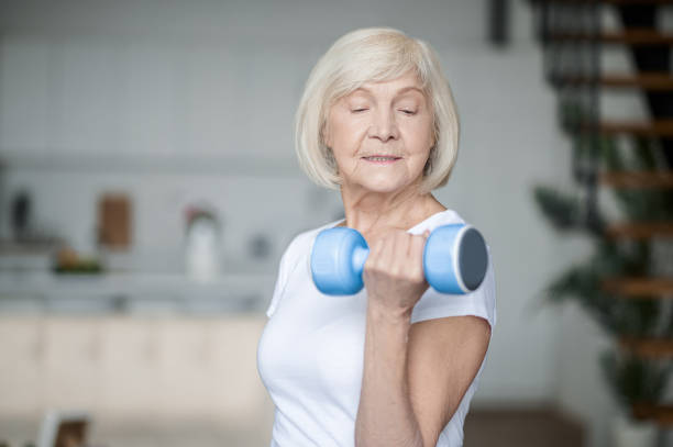 istock Short-haired senior woman exercising with dumbbells 1364384227