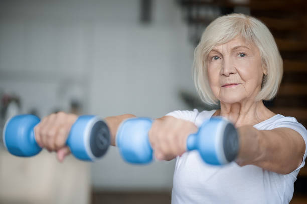 istock Active senior woman with dumbbells in hands doing her workout 1364384230