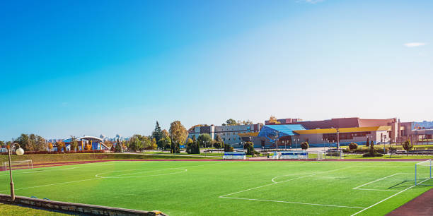 Empty soccer field with bright green grass turf on local town