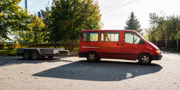 istock old red minivan in tow with open empty metal trailer 1364385695