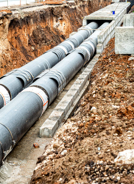 istock Construction works on large iron pipes at a depth of excavated trench 1364386005