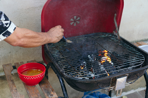 Man cleaning grill for grilling