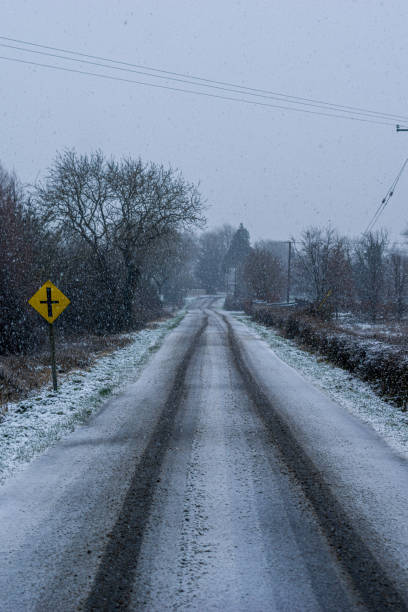 istock Snow falling on a rural road 1364388447
