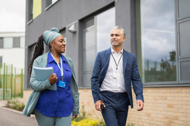 istock Male and female school administrators walking on campus 1364388451