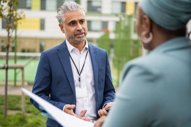 istock School principal and teacher talking outdoors on campus 1364388473