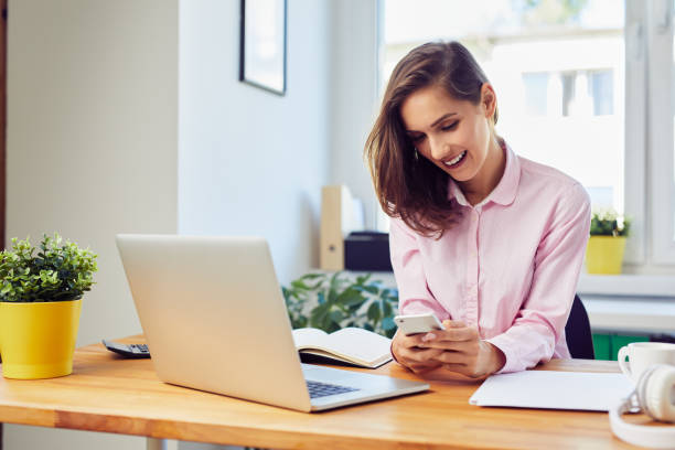istock Young woman working from home texting on mobile phone 1364391145