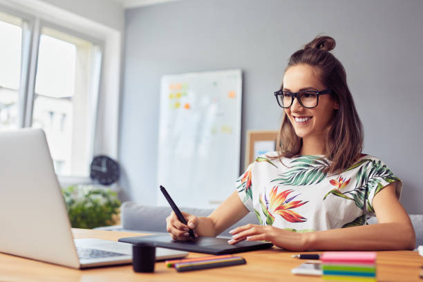 glückliche grafikdesignerin, die vom heimbüro aus mit dem grafiktablett arbeitet - grafiker stock-fotos und bilder