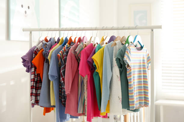 istock Different child's clothes hanging on rack in room 1364392080