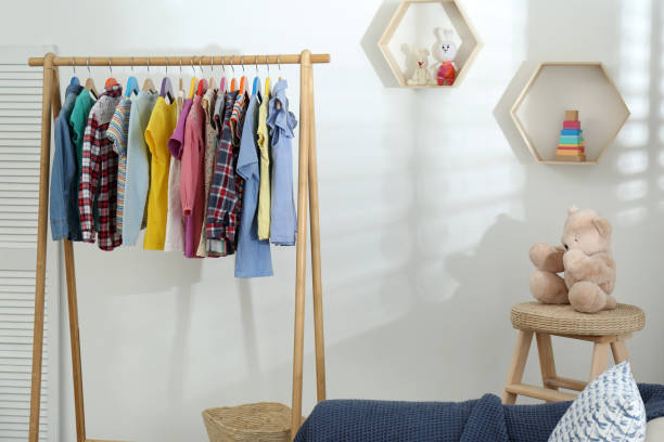 istock Different child's clothes hanging on rack in room 1364392251