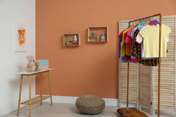 istock Different child's clothes hanging on rack in room 1364392308