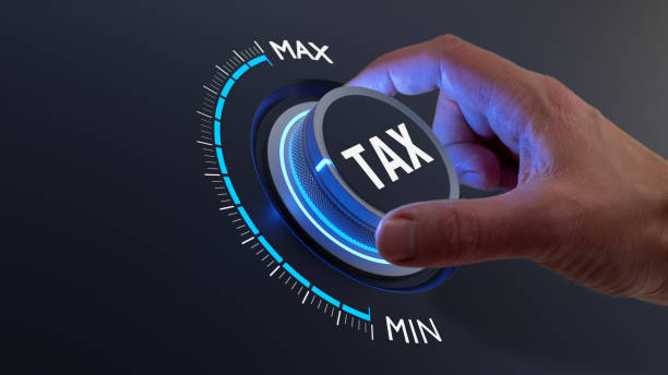 tax reduction and deduction for businesses and individuals. concept with hand turning knob to low taxation rate. return form, exemptions, incentives. - tax imagens e fotografias de stock
