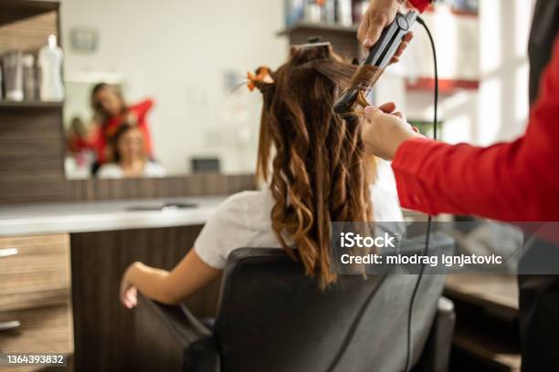 Unrecognizable Hairdresser Using Hair Straightener To Make Curls Stock Photo - Download Image Now