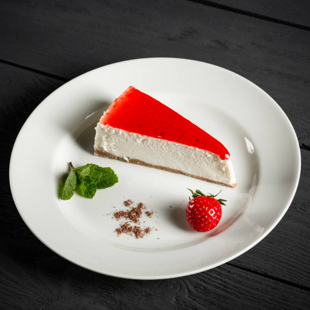 istock Strawberry cheesecake on a white plate. Black wooden background. 1364393993