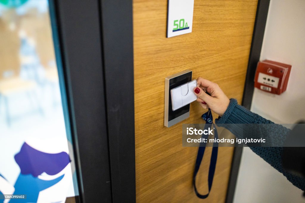 Unrecognizable Caucasian female staff using ID enter key to open the door at the building Accessibility Stock Photo