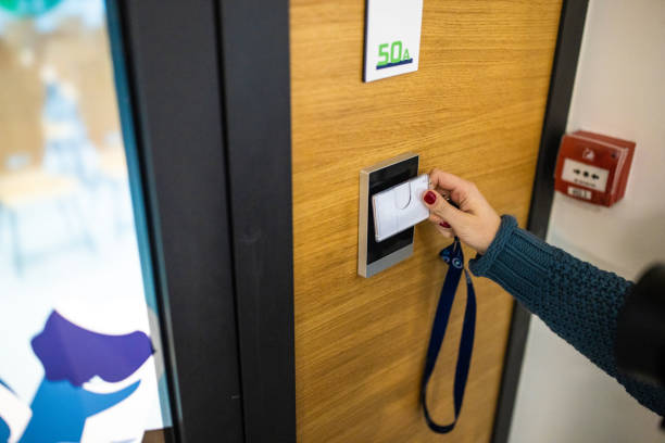 nierozpoznawalna kaukaska pracownica posługująca się kluczem identyfikacyjnym do otwarcia drzwi w budynku - enter key zdjęcia i obrazy z banku zdjęć