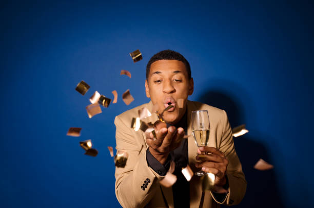 istock Guy with champagne blowing on hand with confetti 1364396504