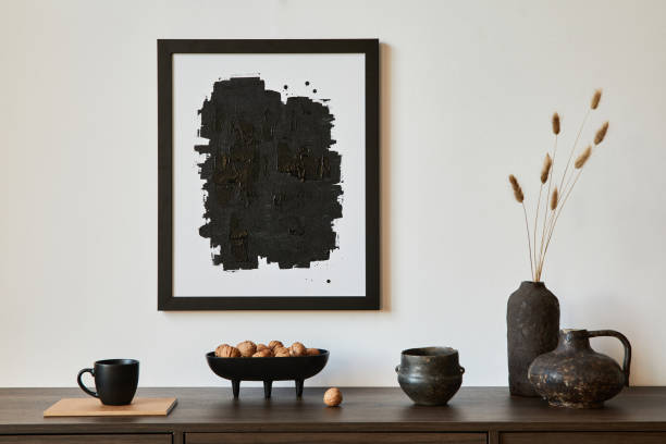 Creative composition of modern living room interior design with mock up poster frame, brown commode, vases and personal accessories. White wall. Copy space. Template.